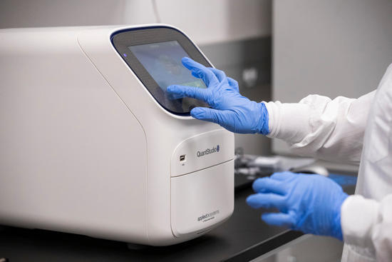 Assistant professor Juliet Morrison conducts a test run on equipment in UC Riverside’s COVID-19 testing laboratory